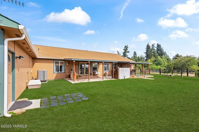 a view of a house with backyard and a tree