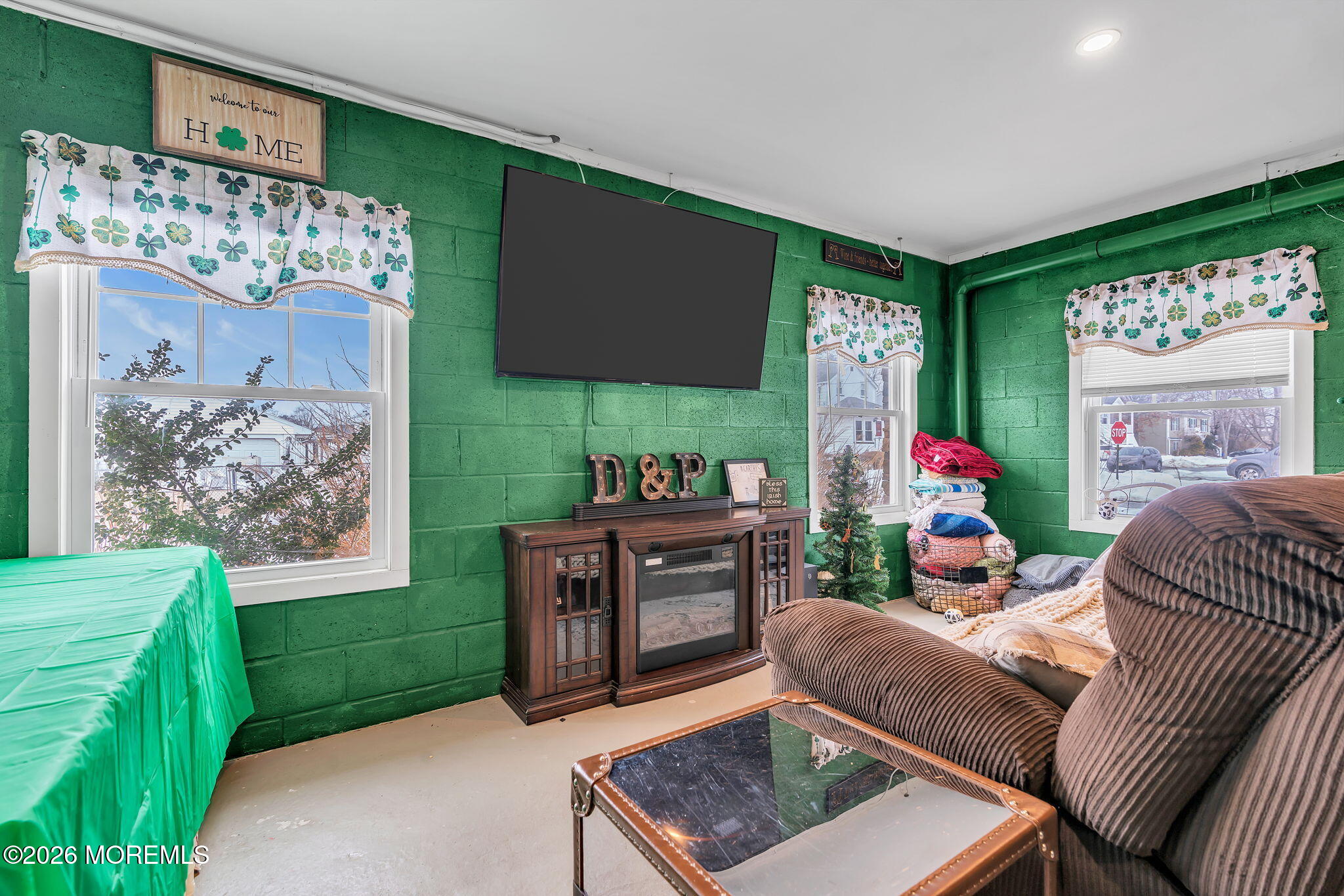 1202 High Avenue Union Beach, NJ 07735 - Photo 37 of 44 a living room with furniture a flat screen tv and a floor to ceiling window