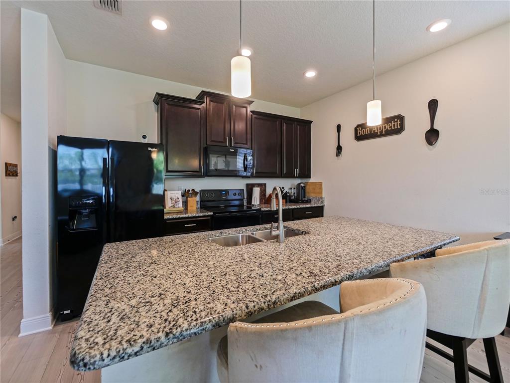 4553 Baler Trails Drive St. Cloud, FL 34772 - Photo 11 of 32 a kitchen with stainless steel appliances granite countertop a sink stove and refrigerator