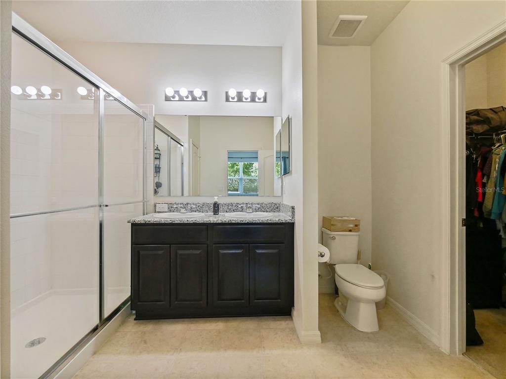 4553 Baler Trails Drive St. Cloud, FL 34772 - Photo 20 of 32 a spacious bathroom with a toilet a sink and a large mirror