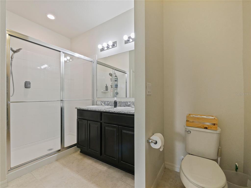 4553 Baler Trails Drive St. Cloud, FL 34772 - Photo 21 of 32 a bathroom with a toilet a sink and mirror