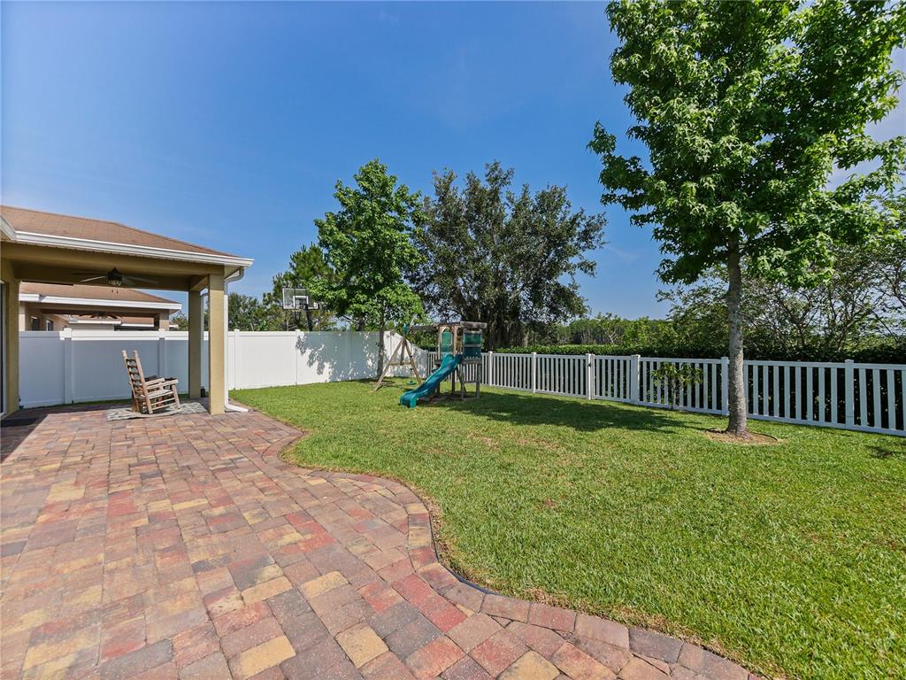 4553 Baler Trails Drive St. Cloud, FL 34772 - Photo 24 of 32 a backyard of a house with plants and wooden fence