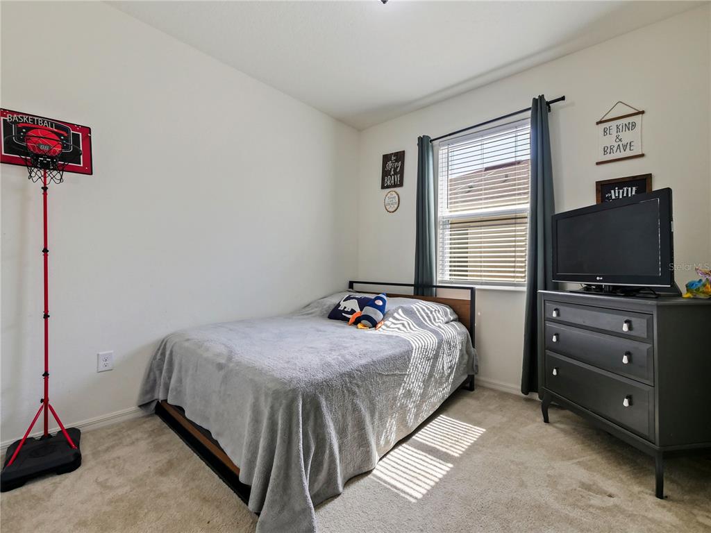 4553 Baler Trails Drive St. Cloud, FL 34772 - Photo 7 of 32 a bedroom with a bed and flat screen tv