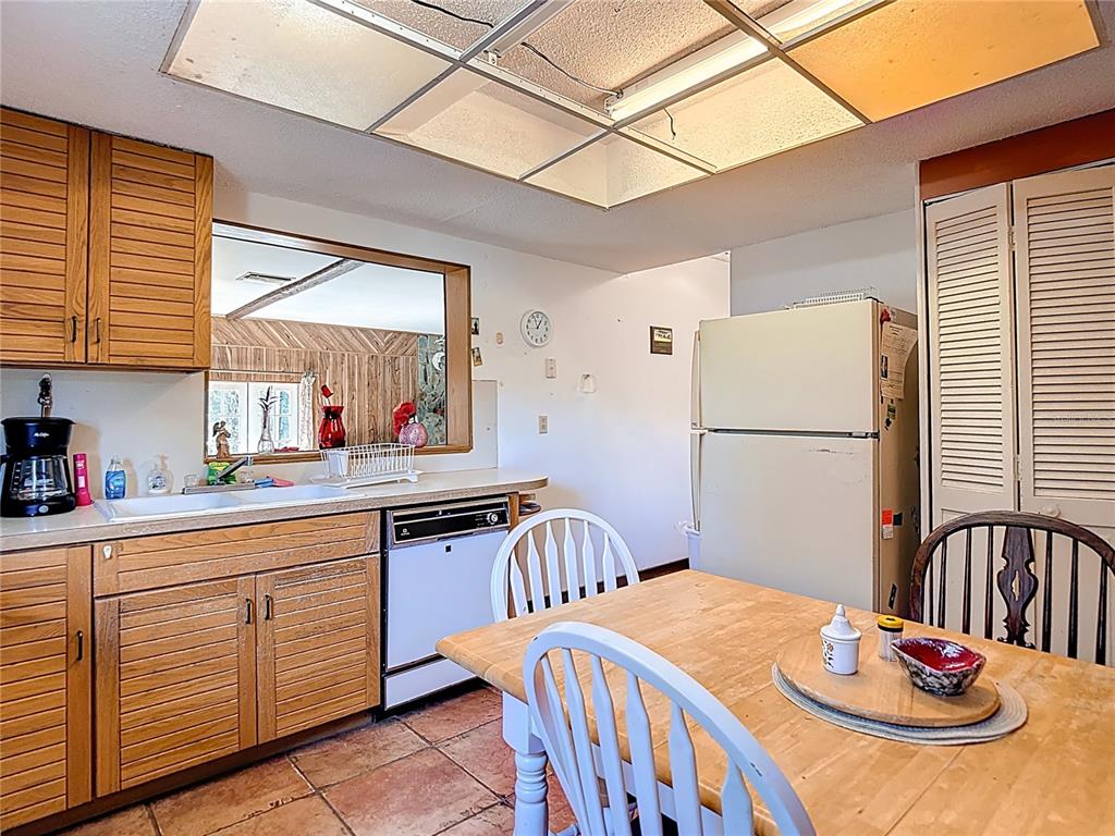 22380 Powell Road Brooksville, FL 34602 - Photo 10 of 45 a kitchen with stainless steel appliances granite countertop a sink a stove a dining table and chairs