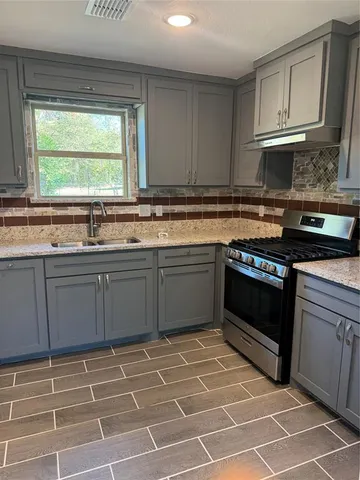 a kitchen with a sink stove and cabinets