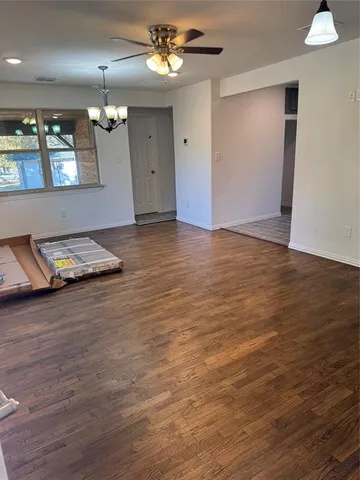 a view of a room with wooden floor and chandelier