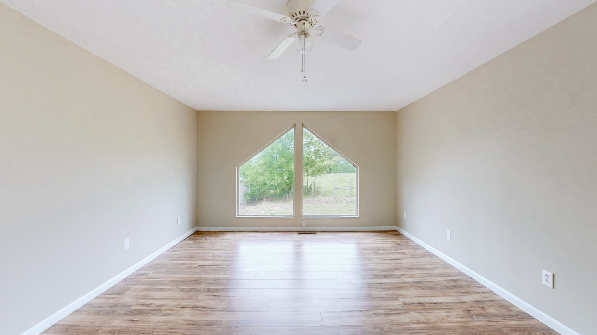 75 Vantrease Road Brush Creek, TN 38547 - Photo 12 of 34 an empty room with wooden floor chandelier fan and windows