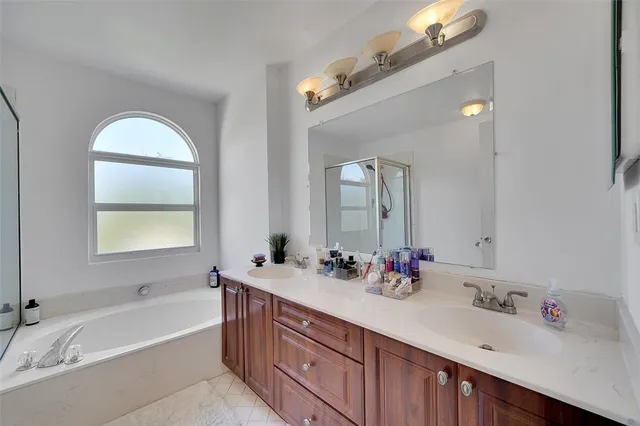 a bathroom with a tub sink and mirror