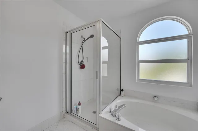 a bathroom with a tub a sink and a window