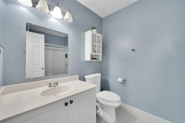 a bathroom with a toilet sink and mirror