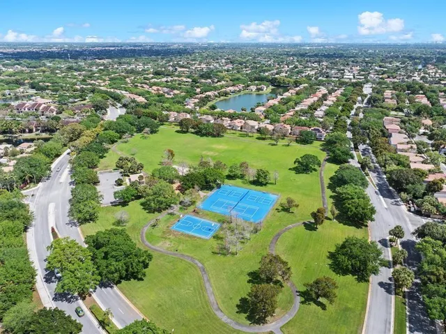 an aerial view of residential houses with outdoor space and trees