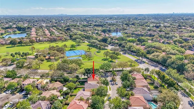 an aerial view of residential houses with outdoor space and trees