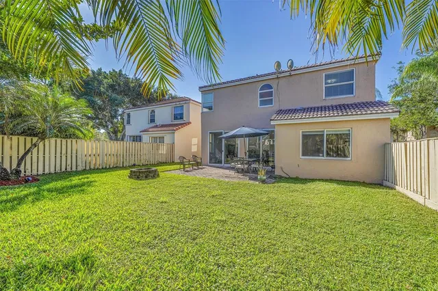 a view of a house with a yard and a tree