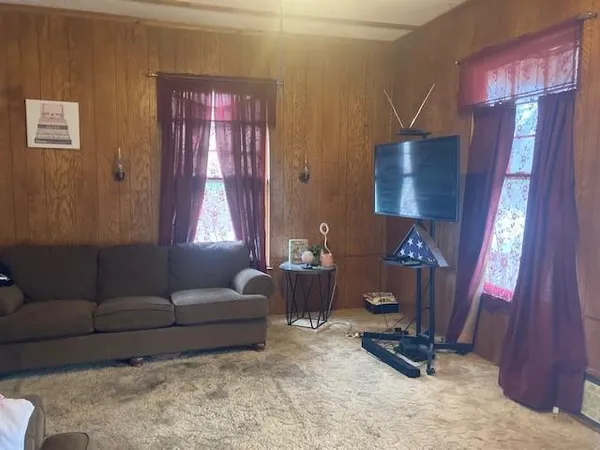 a living room with furniture a rug and a window