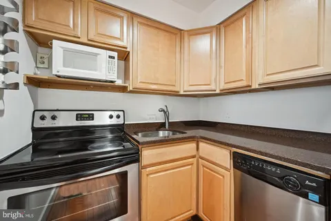 a kitchen with stainless steel appliances granite countertop a stove and a microwave