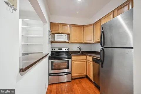 a kitchen with stainless steel appliances granite countertop a refrigerator sink and stove