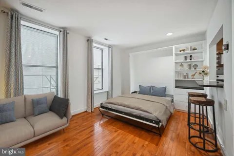 a bedroom with a bed and a bookshelf with wooden floor