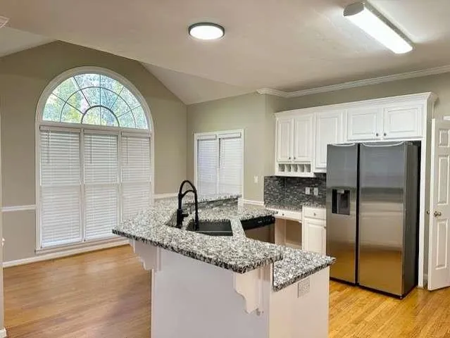 a kitchen with stainless steel appliances granite countertop a sink a stove and refrigerator