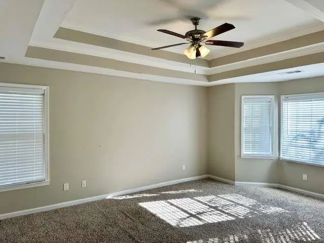 a view of an empty room with window and a ceiling fan