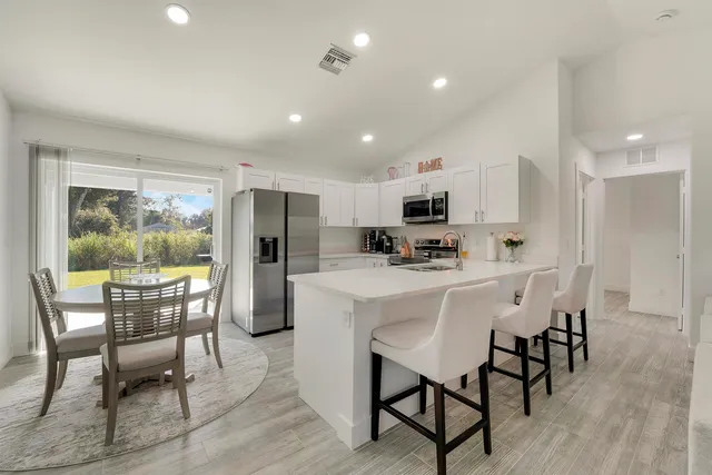a kitchen with refrigerator and chairs