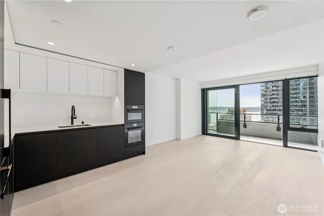 a view of a big room with wooden floor and windows