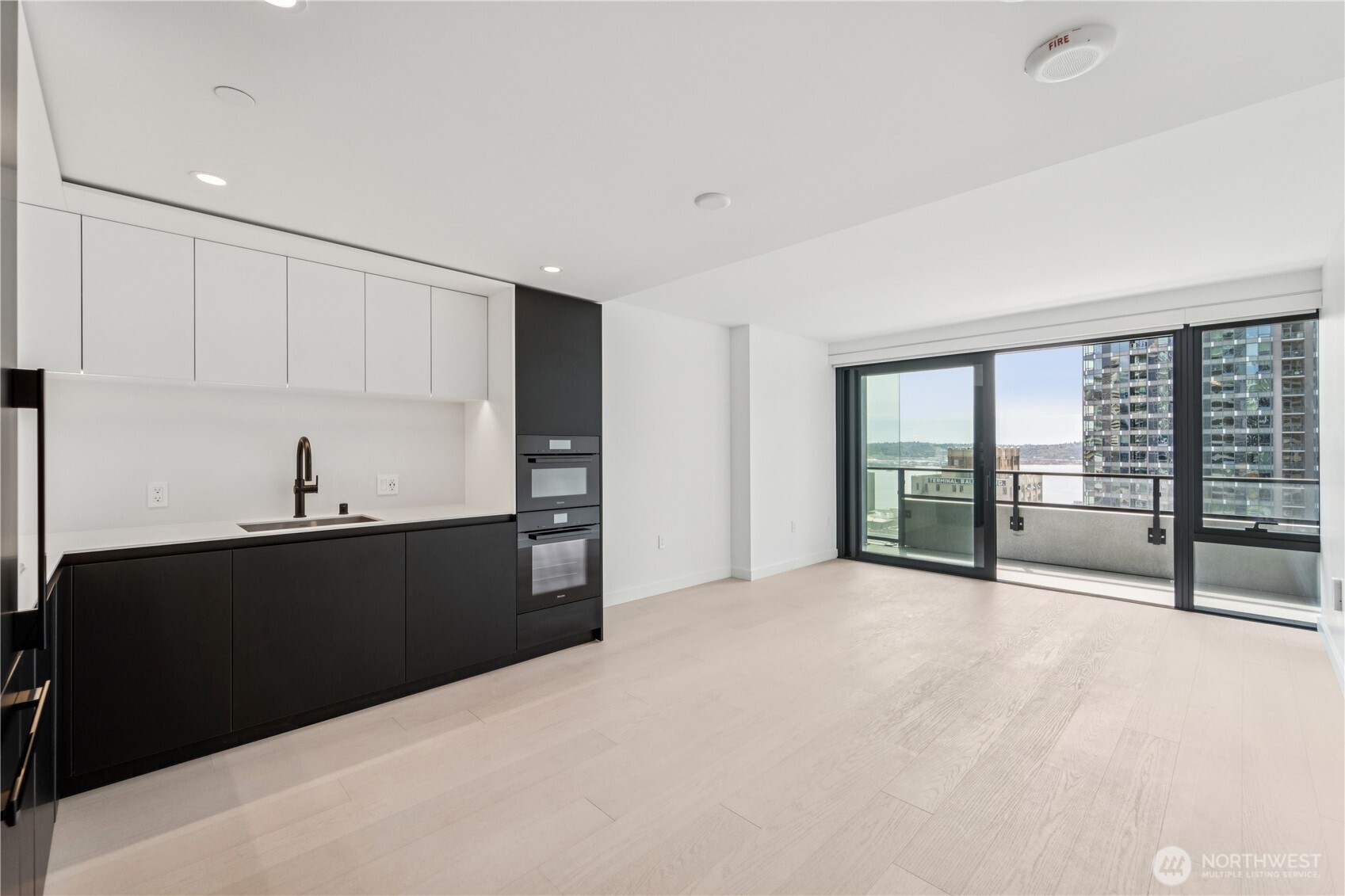 a view of a big room with wooden floor and windows