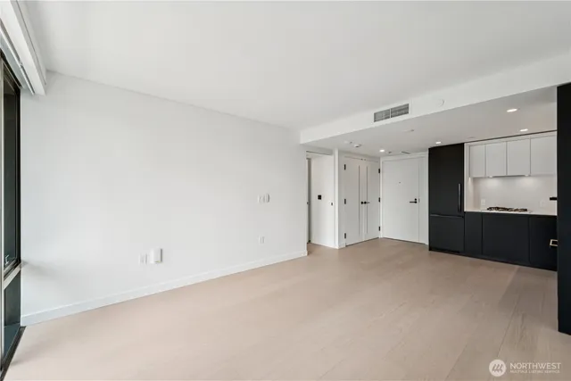 a view of an empty room with a kitchen