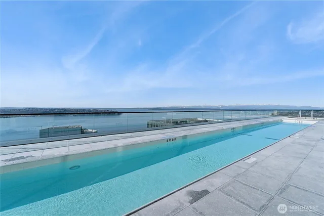 a swimming pool with outdoor seating and city view