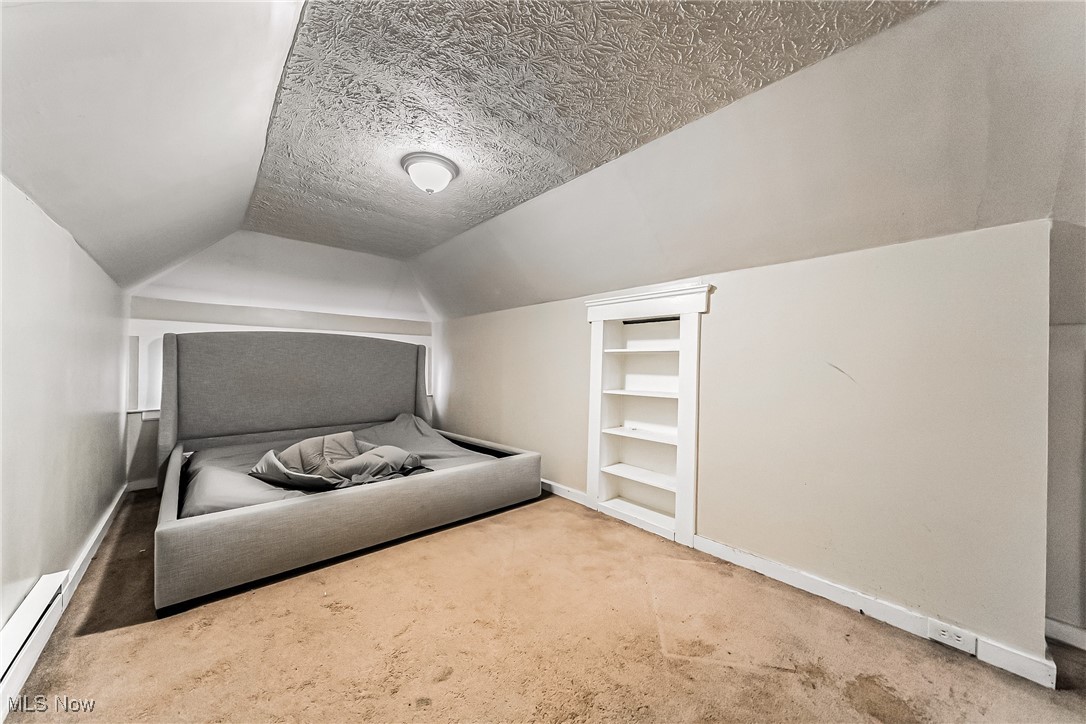 2014 Cook Avenue Cleveland, OH 44109 - Photo 24 of 37 Unfurnished bedroom featuring lofted ceiling, light carpet, a textured ceiling, and baseboard heating