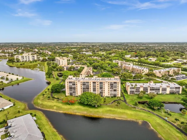 a view of a room with wooden floor kitchen view and a window