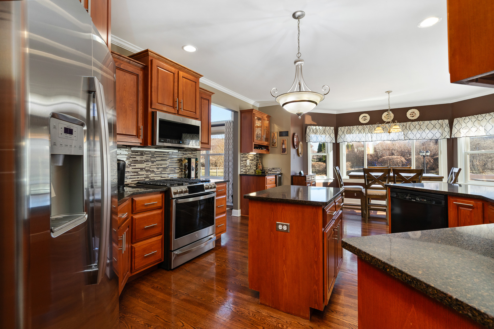 17621 Harper Road Tinley Park, IL 60487 - Photo 12 of 67 a kitchen with stainless steel appliances granite countertop a stove top oven a sink dishwasher a refrigerator and a dining table with wooden floor