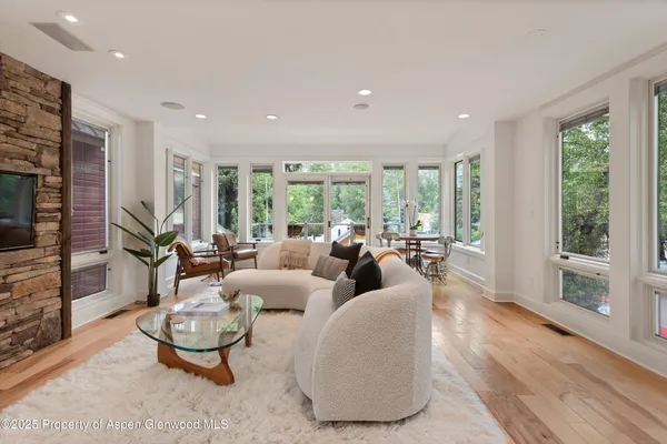 a dining room with furniture and large windows