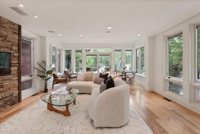 a dining room with furniture and large windows