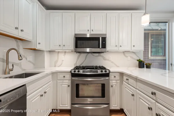 a spacious bedroom with a bed and a chandelier