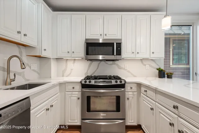 a spacious bedroom with a bed and a chandelier