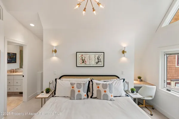 a bedroom with a bed and a large window