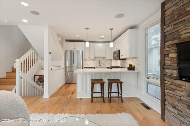 a living room with fireplace furniture and a large window