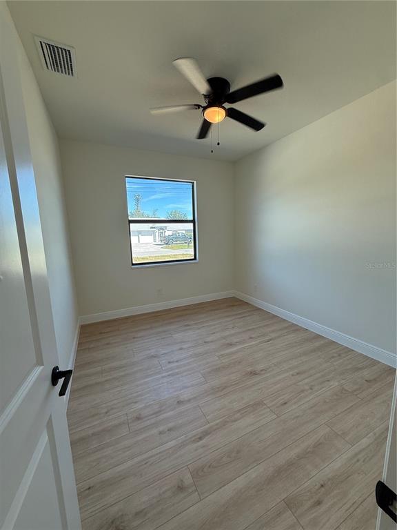 26275 Explorer Road Punta Gorda, FL 33983 - Photo 17 of 22 an empty room with wooden floor fan and windows