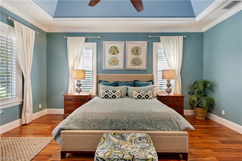 150 Central Avenue Naples, FL 34102 - Photo 11 of 34 a bedroom with a bed and wooden floor