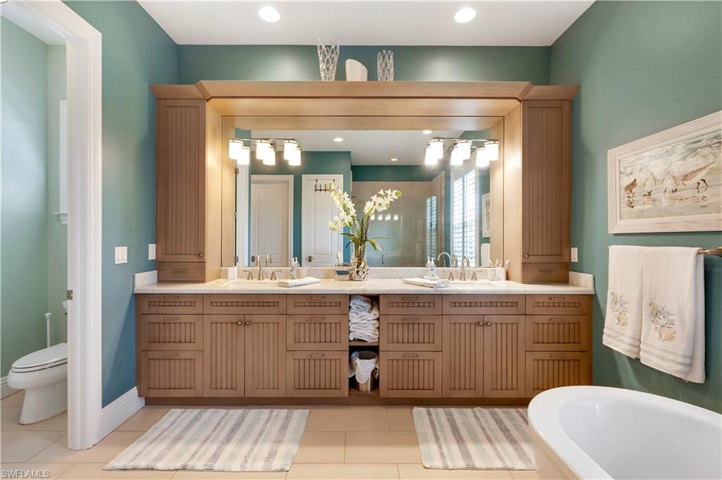 150 Central Avenue Naples, FL 34102 - Photo 13 of 34 a spacious bathroom with a granite countertop sink mirror and a bathtub