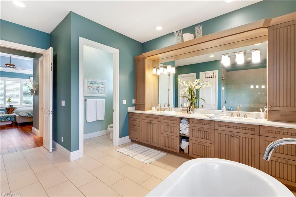 150 Central Avenue Naples, FL 34102 - Photo 14 of 34 a bathroom with a sink and a mirror