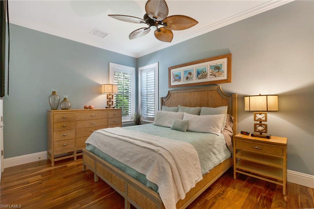 150 Central Avenue Naples, FL 34102 - Photo 18 of 34 a bedroom with a bed and wooden floor