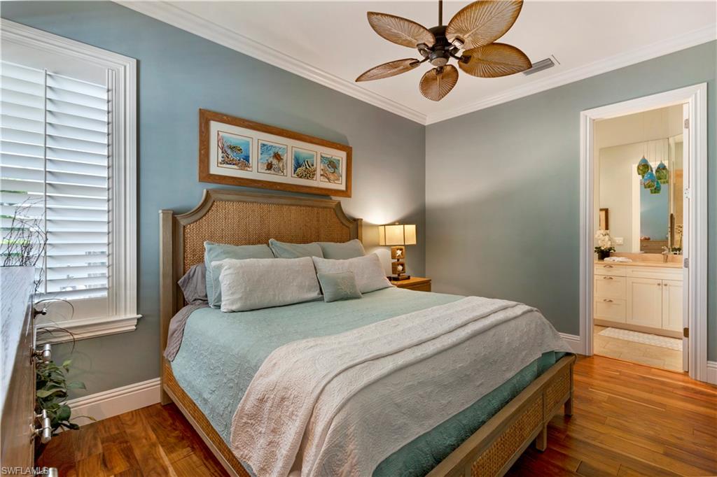 150 Central Avenue Naples, FL 34102 - Photo 19 of 34 a bedroom with a bed and a chandelier