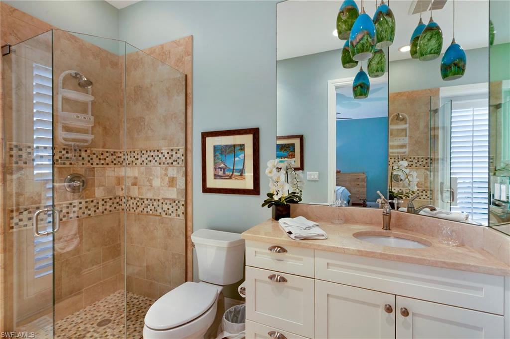 150 Central Avenue Naples, FL 34102 - Photo 20 of 34 a bathroom with a granite countertop sink a toilet a mirror and shower