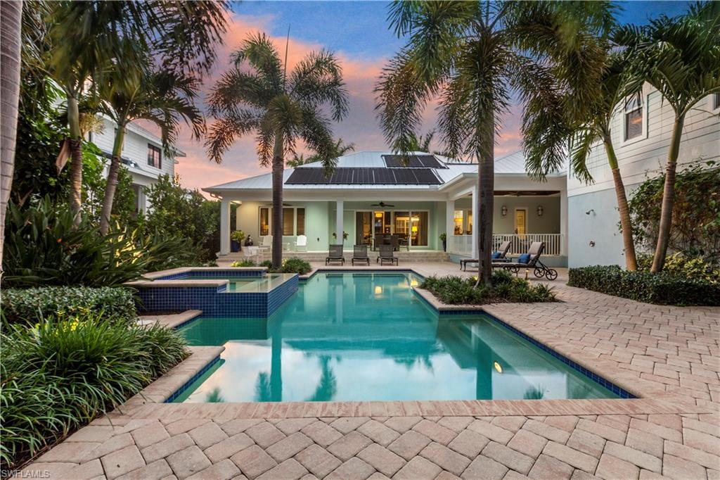 150 Central Avenue Naples, FL 34102 - Photo 26 of 34 a front view of a house with garden and swimming pool