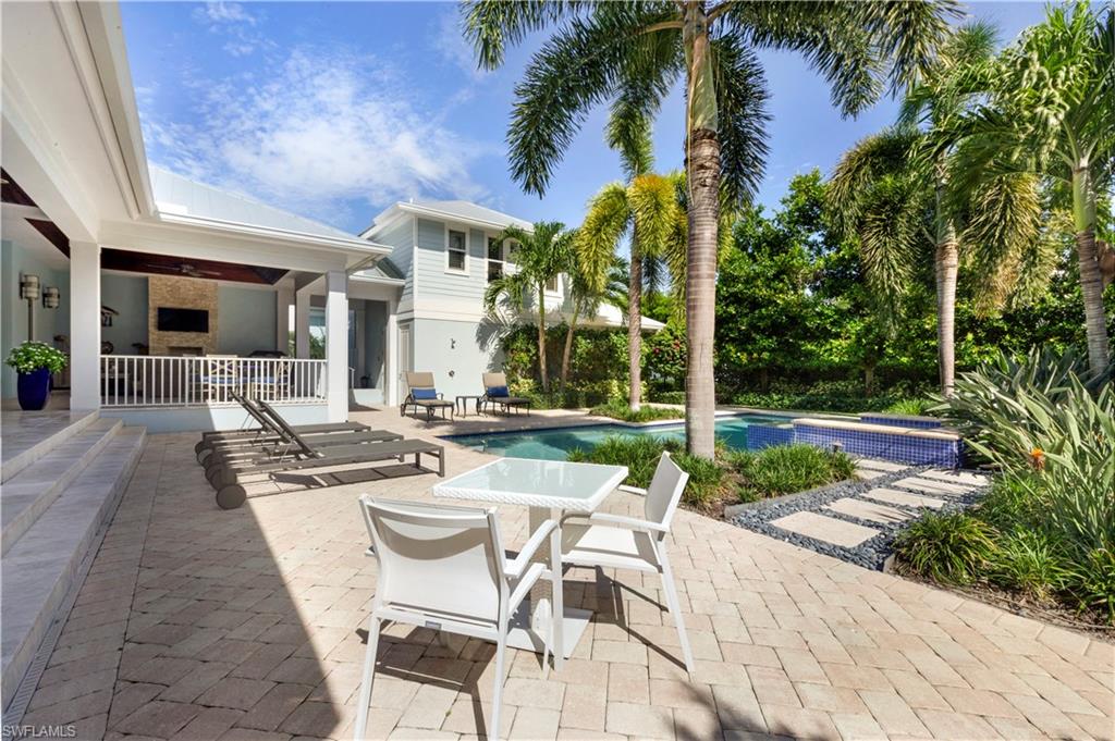 150 Central Avenue Naples, FL 34102 - Photo 28 of 34 a view of a patio with couches table and chairs potted plants and palm tree
