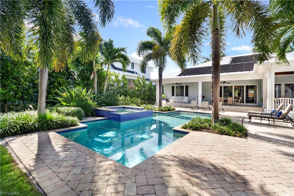 150 Central Avenue Naples, FL 34102 - Photo 29 of 34 a view of a patio with table and chairs potted plants and palm tree