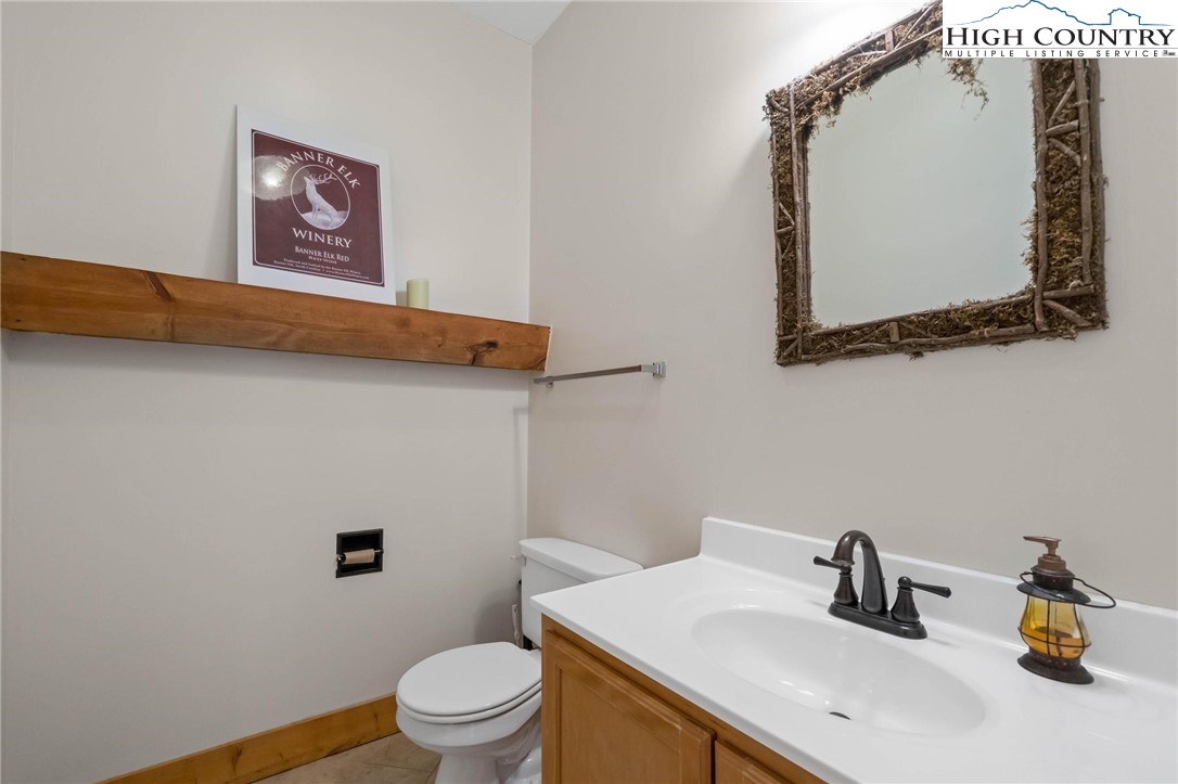 140 Spruce Hollow Road Beech Mountain, NC 28604 - Photo 38 of 50 a bathroom with a toilet sink and mirror