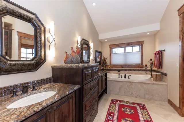 a bathroom with a sink a large mirror and a bathtub