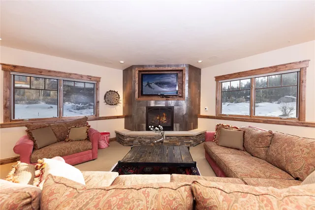 a living room with furniture large window and fireplace